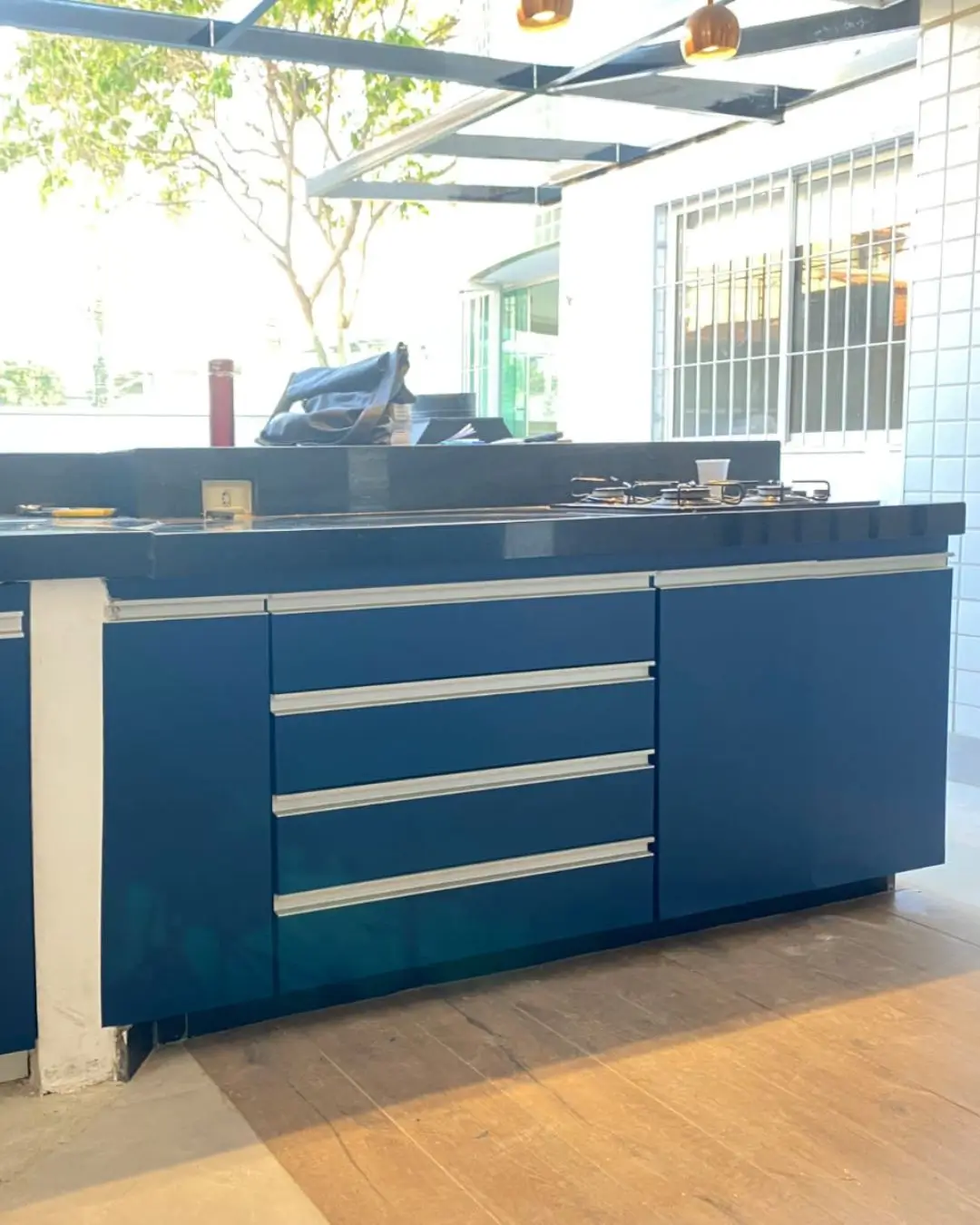 Cozinha planejada envelopada em azul marinho com ilha central, projeto em Belo Horizonte