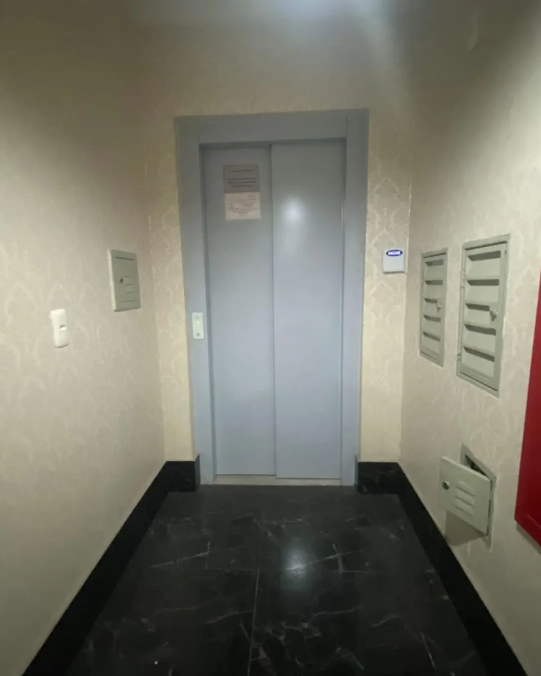 Hall de entrada com elevador em prédio residencial de Belo Horizonte