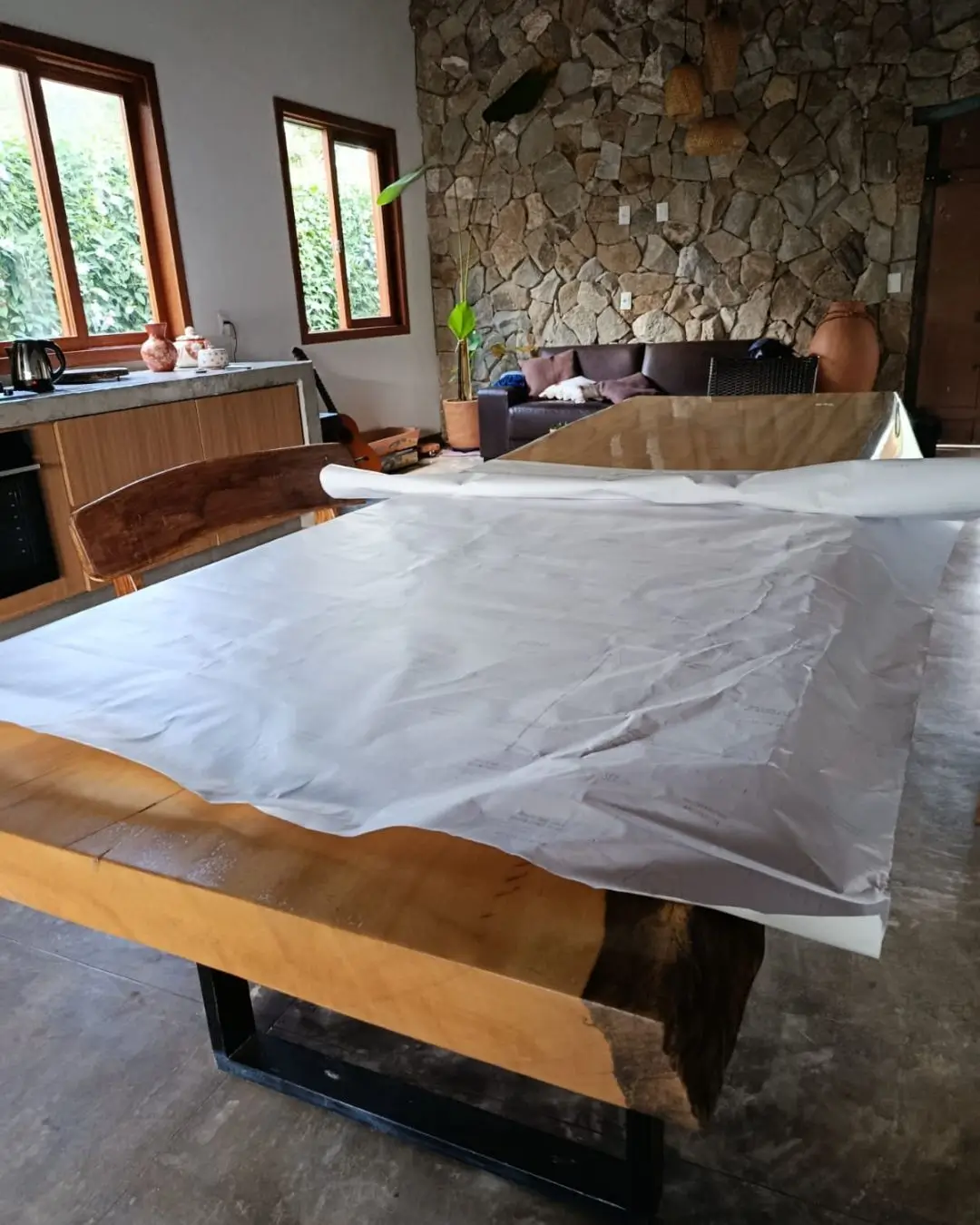 Mesa de madeira protegida com plástico durante instalação de envelopamento, Belo Horizonte